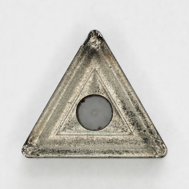 Used triangular carbide insert with a center screw hole