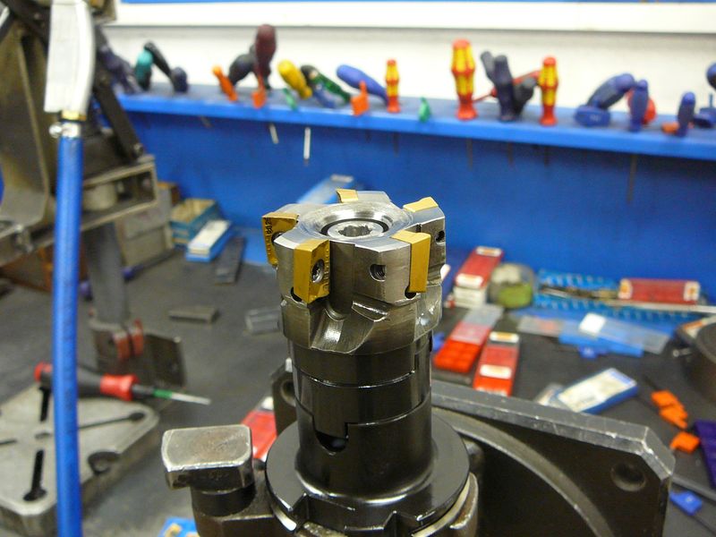Face mill body with carbide inserts around its rim